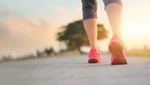 woman walking on country road as sun is setting