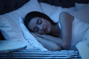 young woman sleeping in bed at night