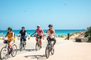 Group riding bikes on the beach