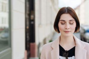 woman closing her eyes to peacefully keep her composure