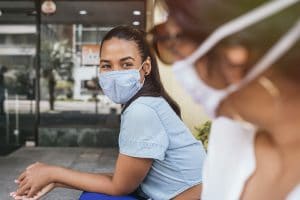 two nurses with masks on talking outside of hospital