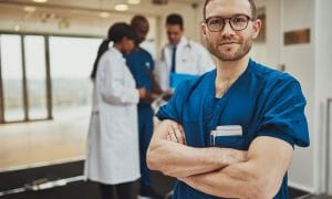 male nurse standing confidently with arms crossed.