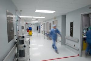 nurse walking swiftly down hospital hallway