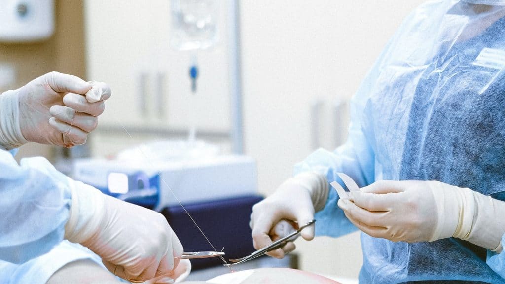 Nurses suturing up a patient in the operating room