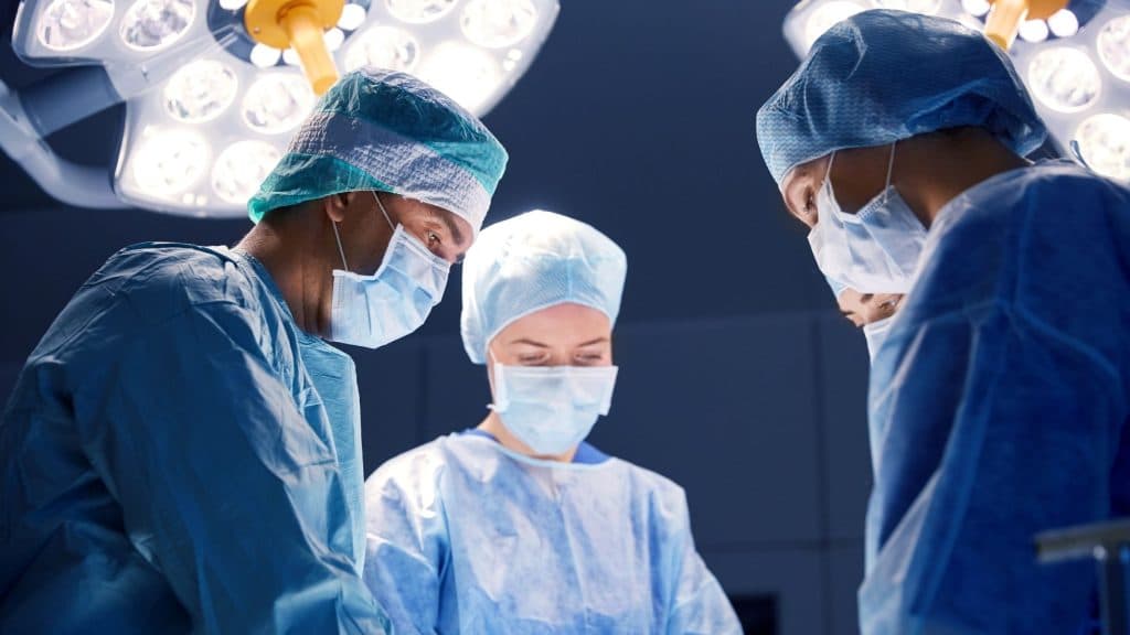 nurses and surgeons looking at a patient in the operating room